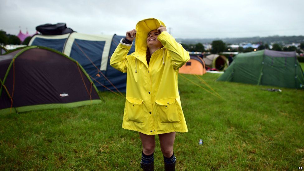 Girl wearing a mac by some tents