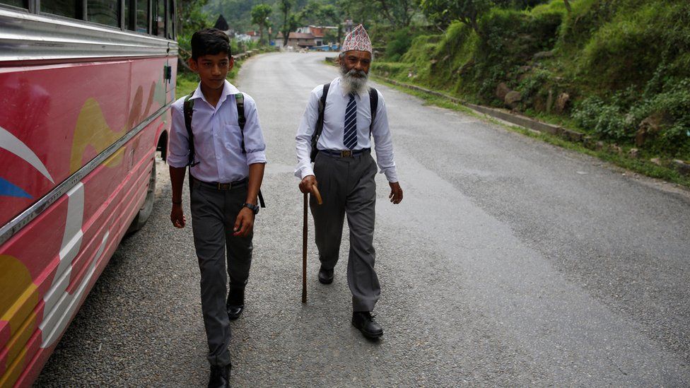 Mr Kami walks with his classmate Sagar Thapa