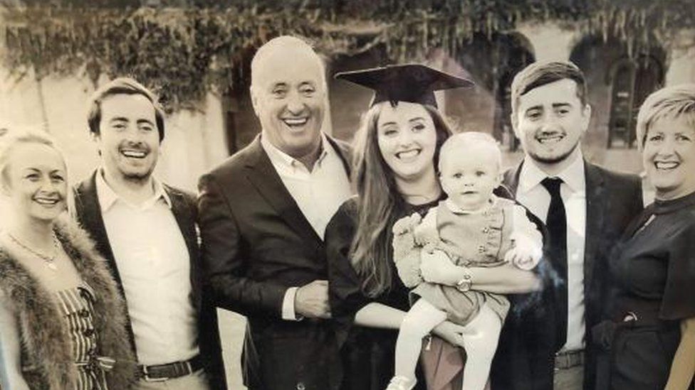 A black and white photo of Grace Millane with her family