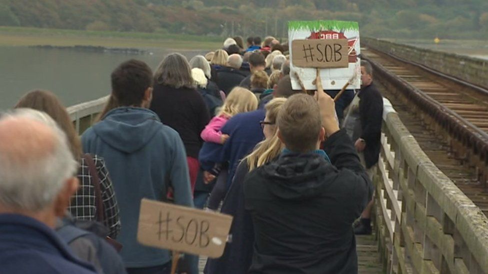 Campaigners held Save Our Bridge banners as they made their way across the estuary