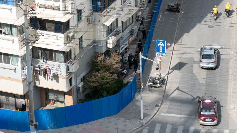 Blue iron walls are used to temporarily isolate and control a residential community in Shanghai, Oct 25