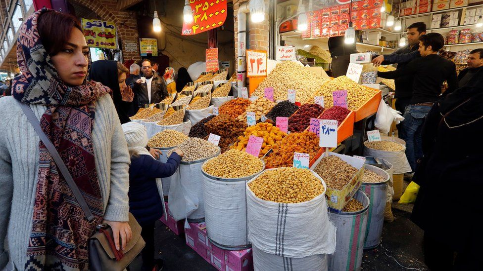 A shopper passes a food stall in Tehran's Grand Bazaar.
