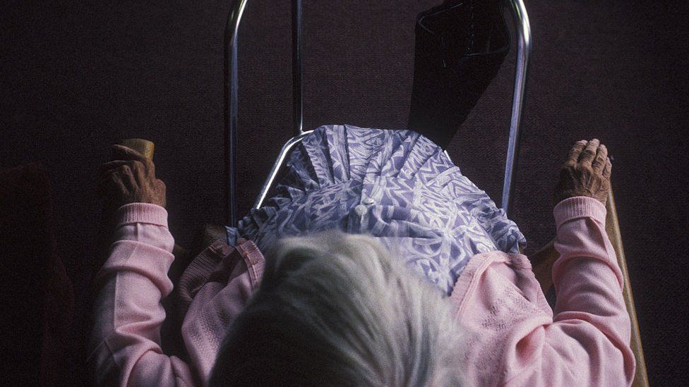 Woman with zimmer frame in residential home for the elderly