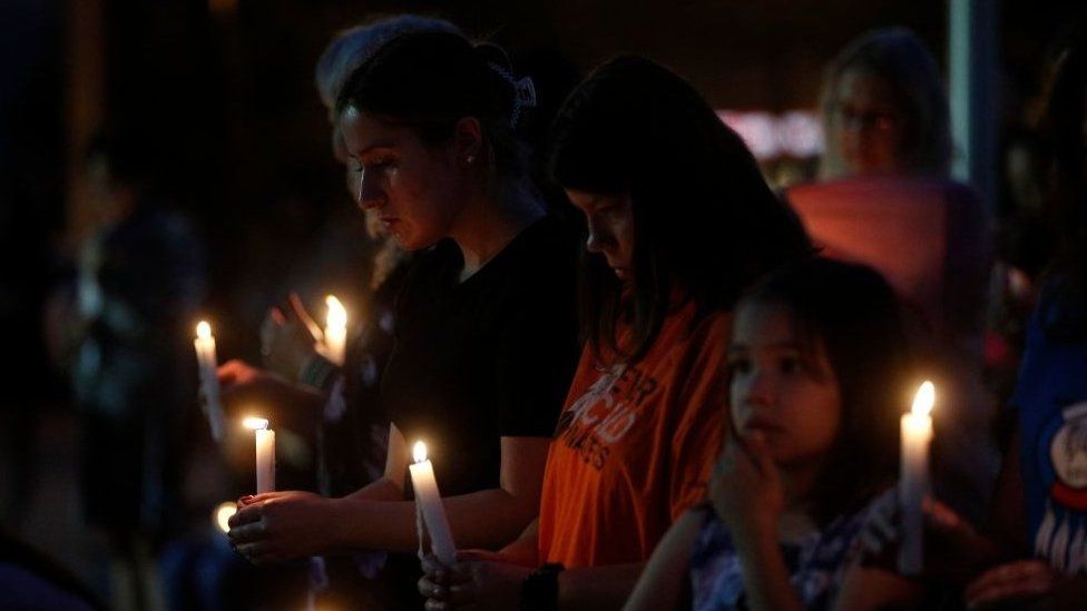 People hold candles during a vigil for the stabbing attack victims in Saskatchewan.