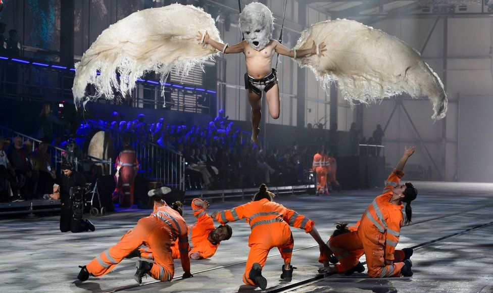 Artists perform during a show on the opening day of the Gotthard rail tunnel - men playing construction workers and a bird above them - 1 June 2016