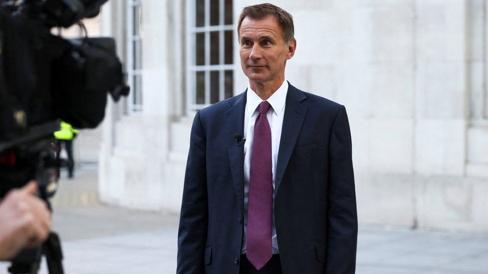 Chancellor Jeremy Hunt in front of cameras.