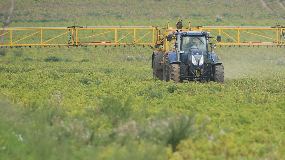 A tractor spraying chemical pesticide