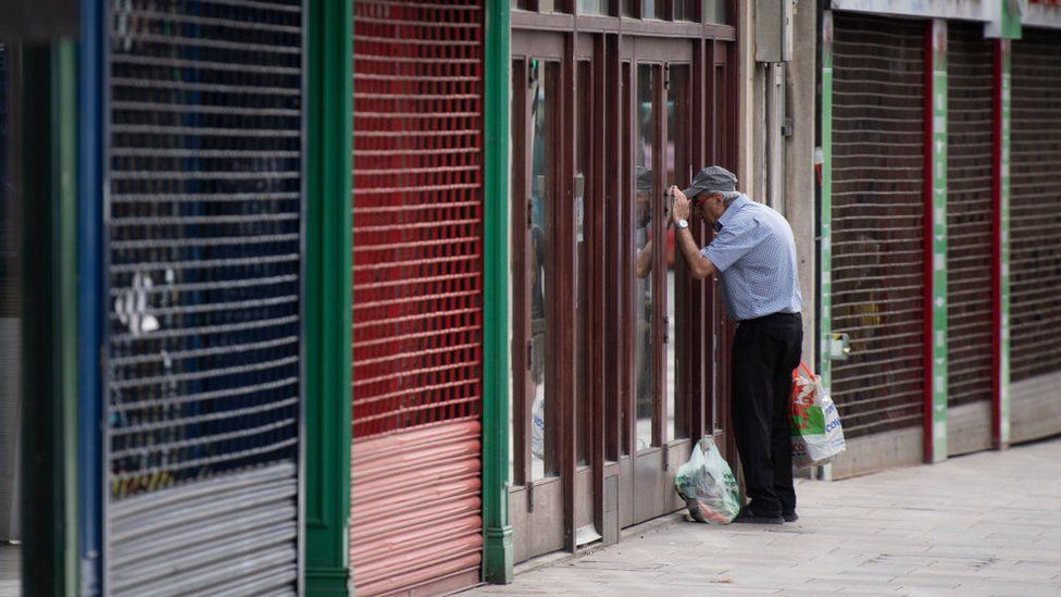 A man looking through a shop window