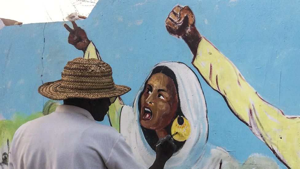 An artist painting a mural of Alaa Salah, the 22-year-old student protester, in Khartoum, Sudan