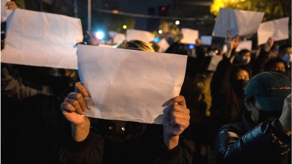 Protesters hold up a white piece of paper against censorship as they march during a protest against Chinas strict zero COVID measures on November 27, 2022 in Beijing, China