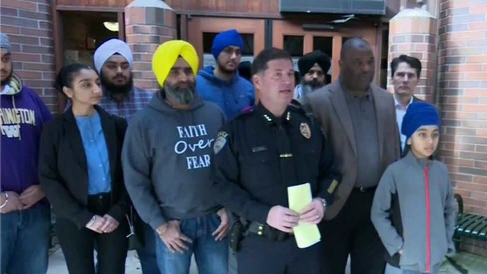 Gathered members of the Sikh community in Kent stand behind the local police chief at a press conference