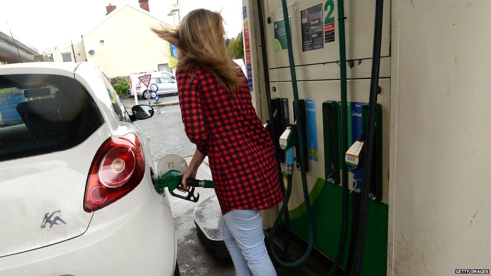 A woman filling up her car at the pump