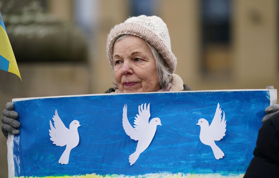 A woman holds a banner as members of northeast Ukrainian community groups gather at Grey's Monument to mark the first anniversary of the Russian invasion of Ukraine, on February 24, 2023 in Newcastle upon Tyne, United Kingdom.