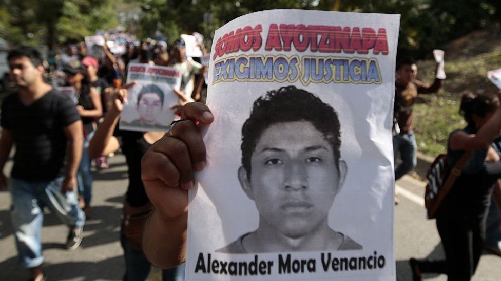 Студенты держат плакат с изображением Александра Мора, читающего «Мы требуем справедливости» во время марша протеста в Текоанапе, штат Герреро, Мексика, 11 декабря 2014 года.
