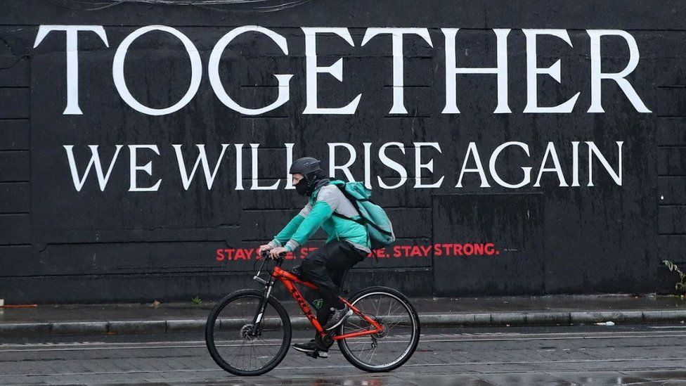 A cyclist passes a mural in Dublin City centre as the Irish government considers new coronavirus restrictions