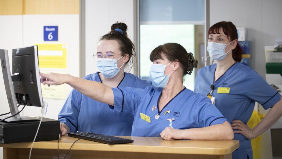 Nurses check information on a screen