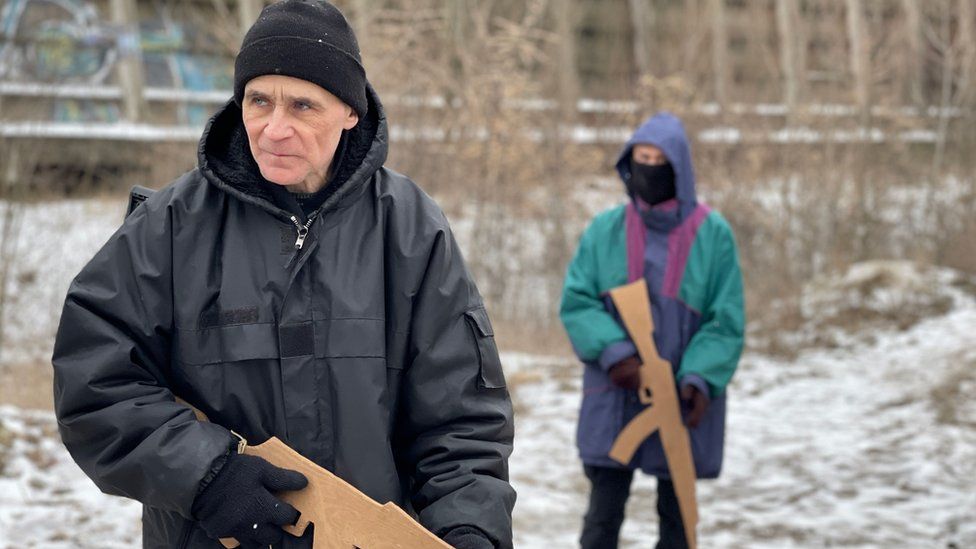 Vasyl (left) carries a wooden gun