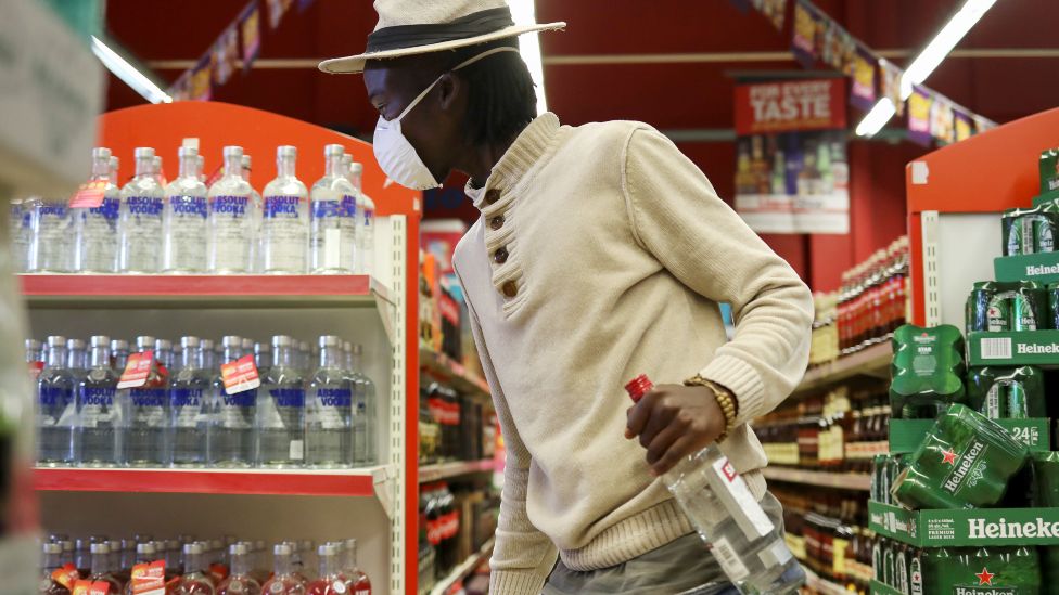 A man holding a vodka bottle in supermarket in Soweto, South Africa - June 2020