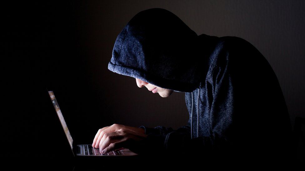 Hooded man on laptop