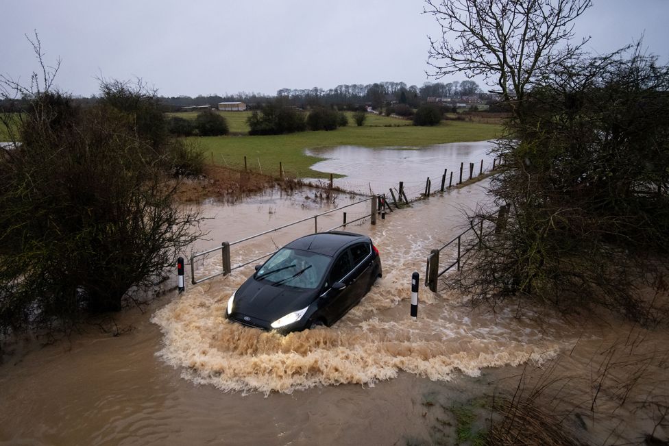 Cars pass through a flooded road in Leicester, on 14 January 2021