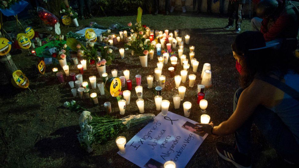 A woman lights candles at the vigil