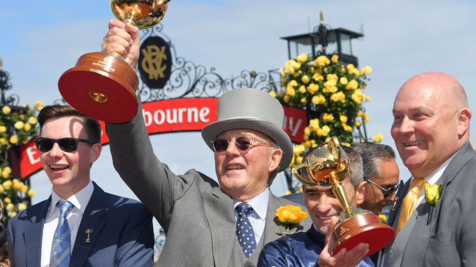 Horse owner Lloyd Williams (middle) holds up the Melbourne Cup trophy with colleagues after his horse Rekindling won the 2017 race