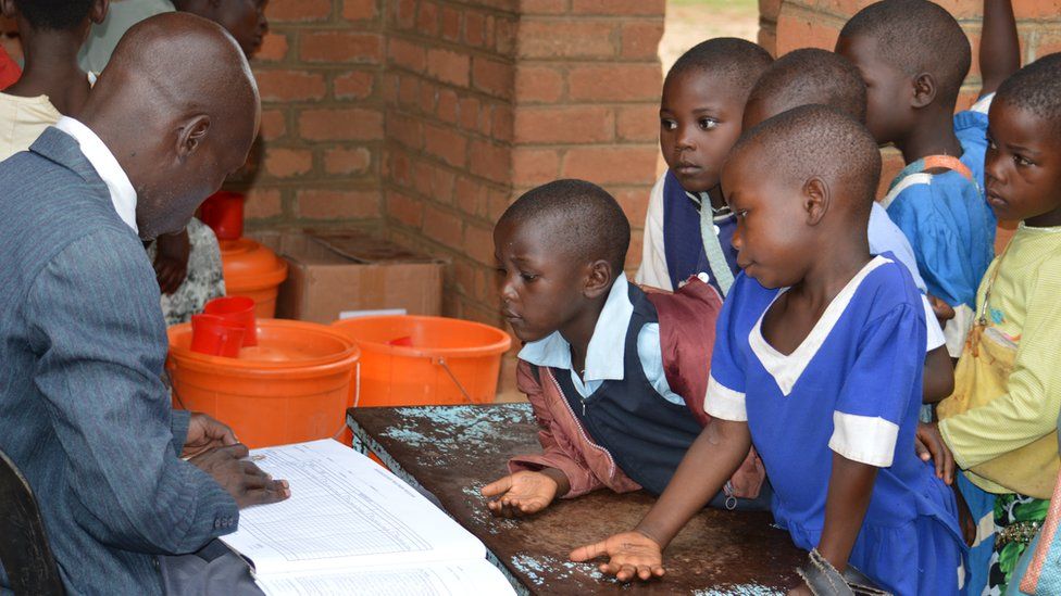 Children waiting in line for tablets to treat an infectious disease