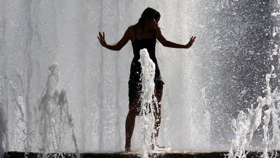 A girl stands in a fountain in downtown Prague as a heat wave hits the Czech Republic, 1 August 2017