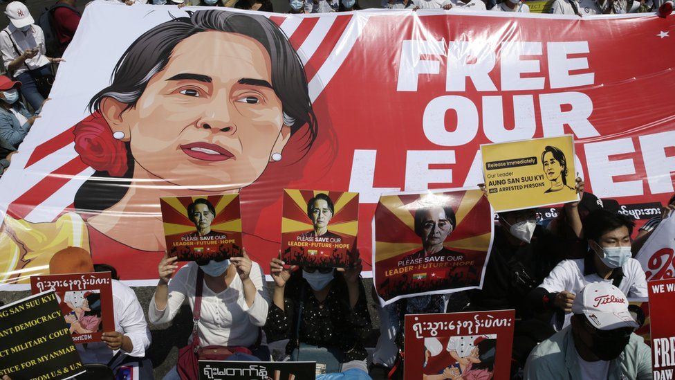Демонстранты держат плакаты и транспаранты, призывающие к освобождению задержанного государственного советника Мьянмы Аун Сан Су Чжи