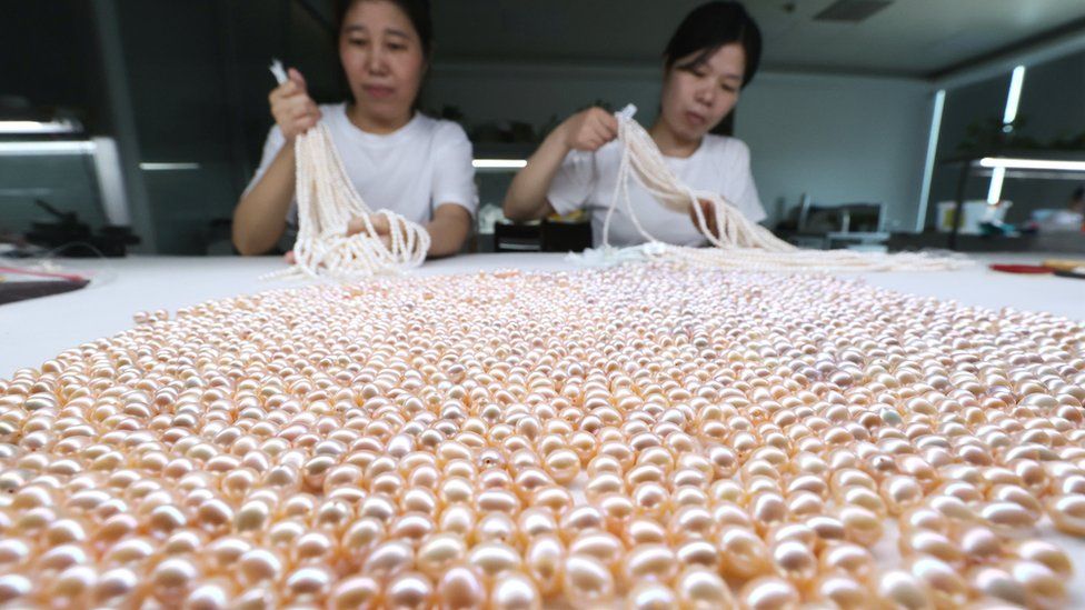 Workers sort out pearls at a factory on July 20, 2022 in Huzhou, Zhejiang Province of China. (
