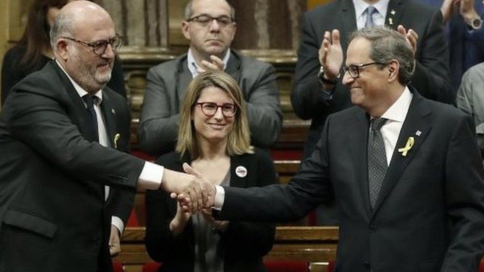Quim Torra (R), is applauded by his party after addressing his investiture session at the regional parliament on 14 May 2018