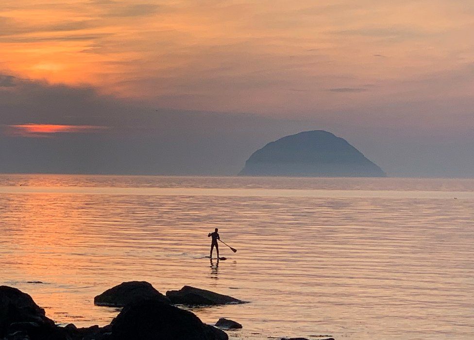 Paddle boarder at sunset