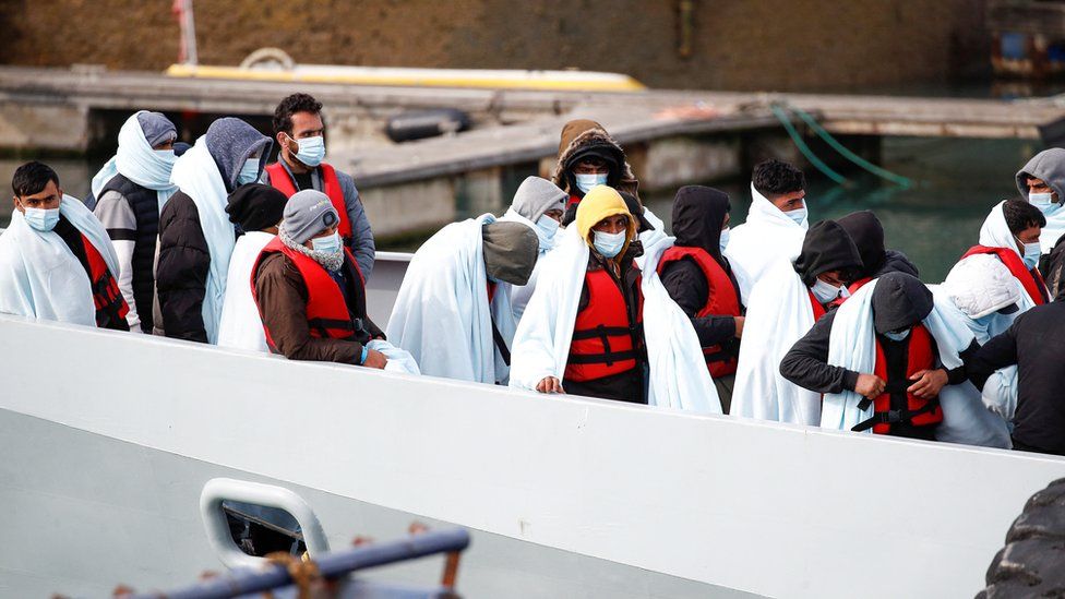 Migrants wait to disembark a boat the the Port of Dover
