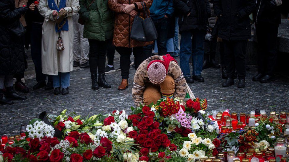 People mourn outside the Charles University building following a mass shooting yesterday, on December 22, 2023 in Prague, Czech Republic.