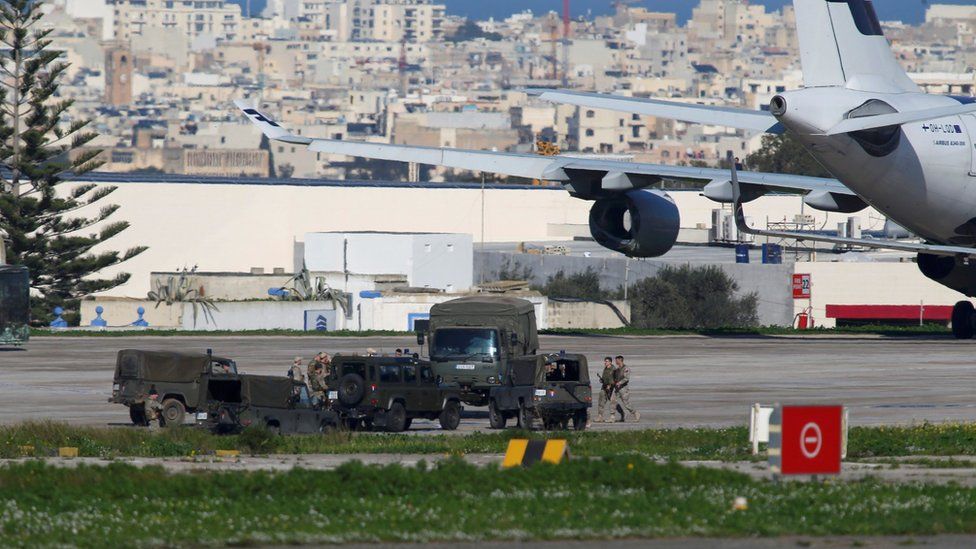 Maltese troops survey a hijacked Libyan Afriqiyah Airways Airbus A320