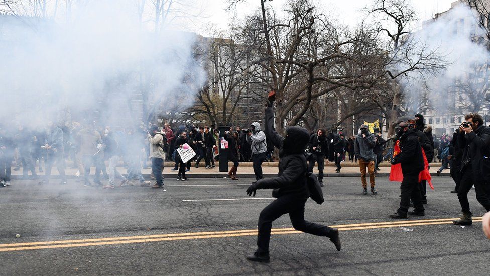 A protester lobs a brick at police during protests in Washington during the inauguration of Donald Trump