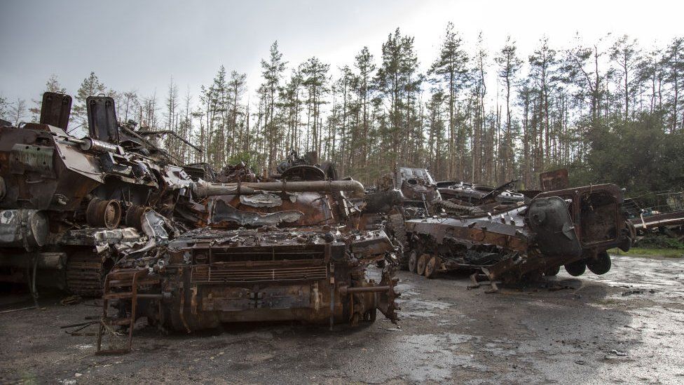 Destroyed armoured vehicles abandoned in muddy ground