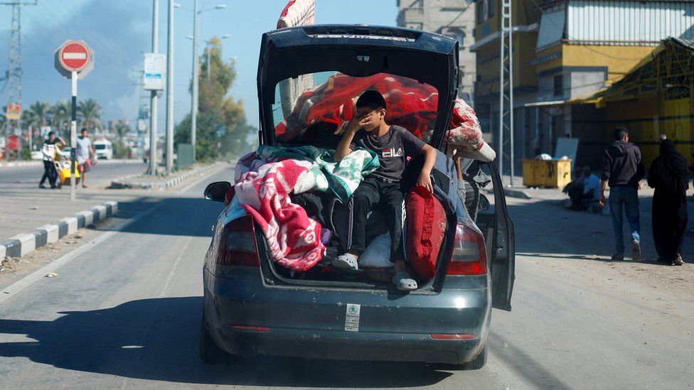 A Palestinian boy sits in the boot of a car in Khan Younis, in southern Gaza (16 November 2023)