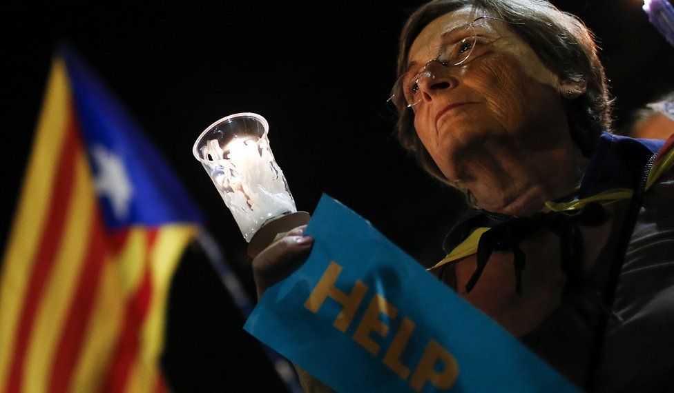 A woman holds a candle during a demonstration in Barcelona against the arrest of two Catalan separatist leaders, 17 October 2017
