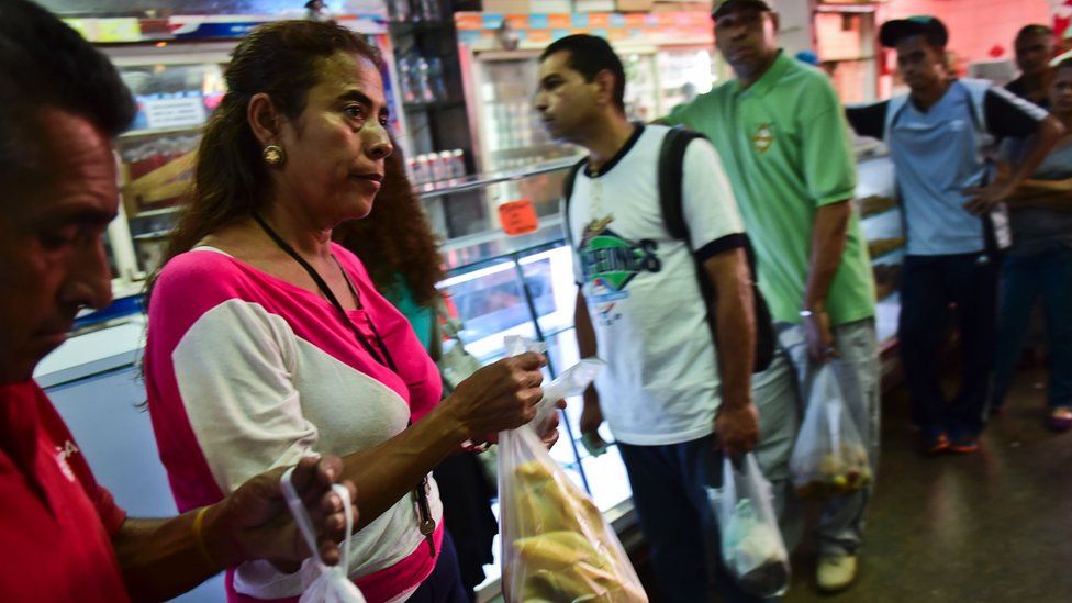 People buy bread in a bakery in Caracas, on September 14, 2016.