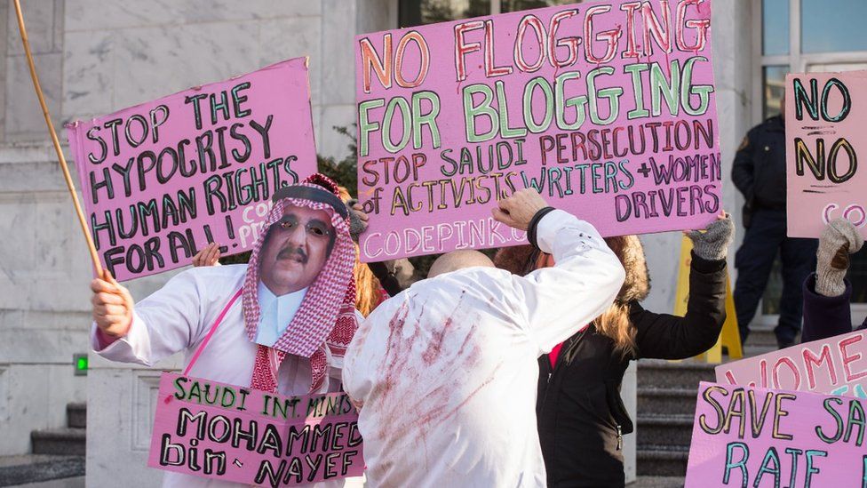Protesters simulate a flogging in front of the Saudi embassy in Washington,DC on January 15, 2015 during a demonstration against the 10-year prison sentence and 1,000 lashes of Saudi activist Raef Badawi for 'insulting Islam' in a blogpost