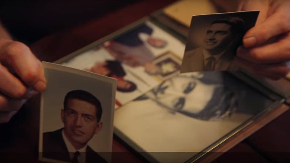 Jack Zawadski holds photos of his husband Robert Huskey