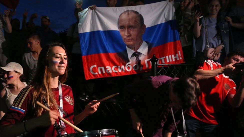 Russian fans wield a national flag bearing the words "Thank you, Putin"
