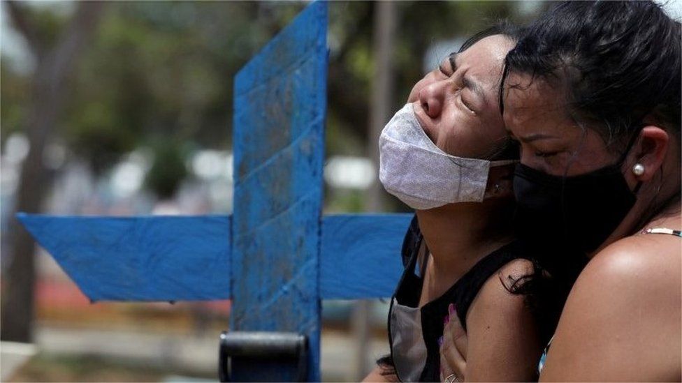 Woman reacts during the burial of her mother in Manaus