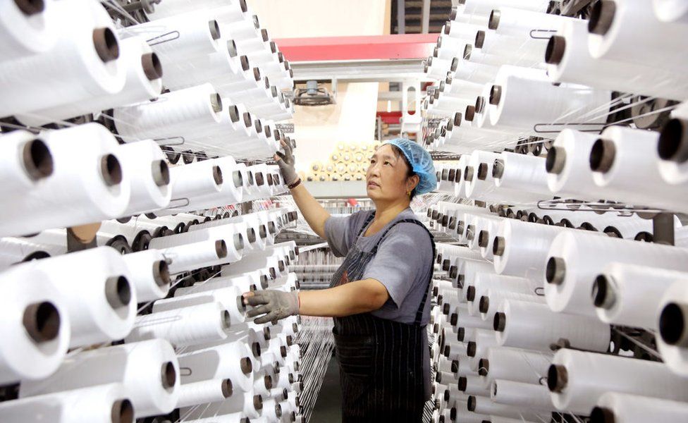A worker works on a production line at a packaging company in Lianyungang city, East China's Jiangsu province, Sept 27, 2023