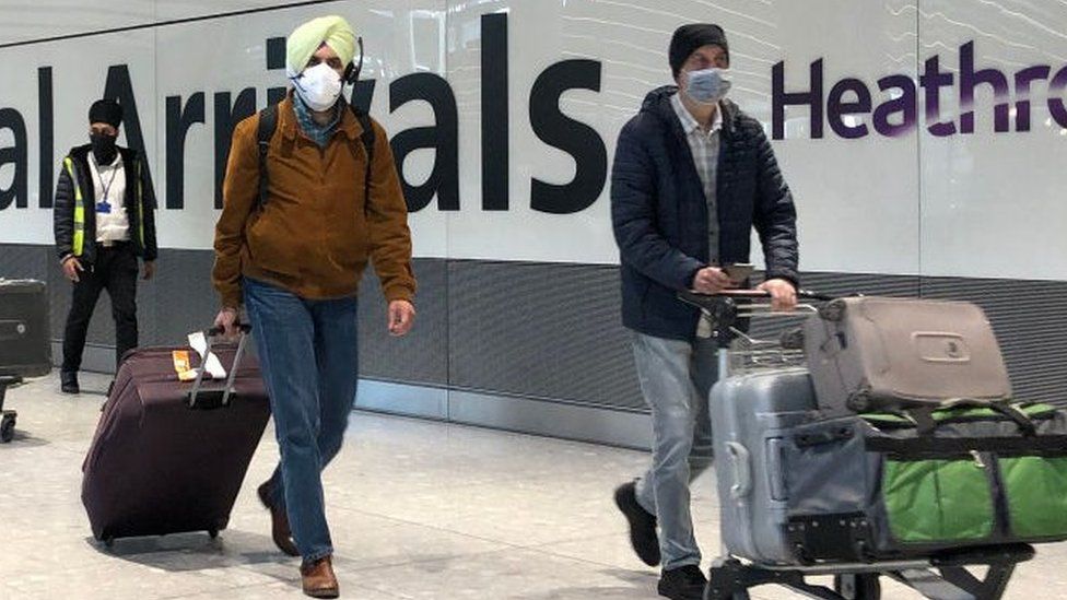 Passengers are escorted through the arrivals area of terminal 5 towards coaches destined for quarantine hotels, after landing at Heathrow airport