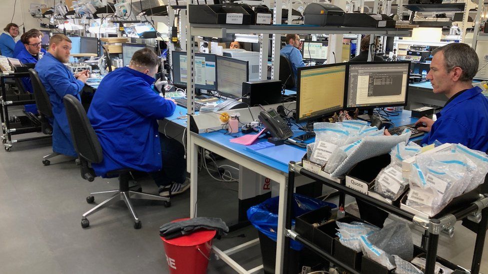 A room of phone repair technicians fixing devices