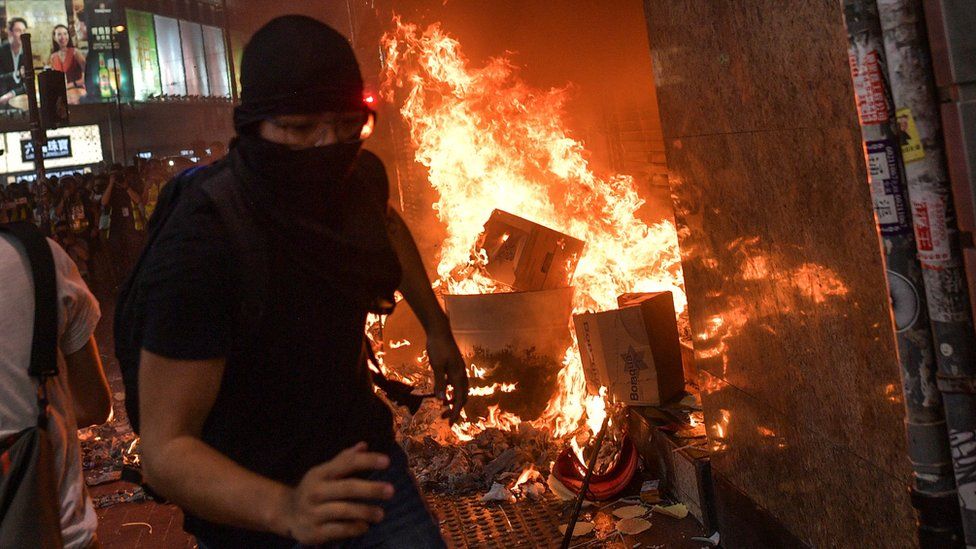 Protesters set fires outside Causeway Bay station in Hong Kong after the government banned face masks