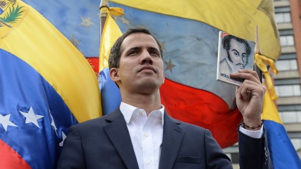 Juan Guaidó holds up the Venezuelan constitution in Caracas on 23 January 2019