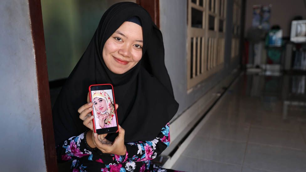Ely Susiawati with a photo of her mother